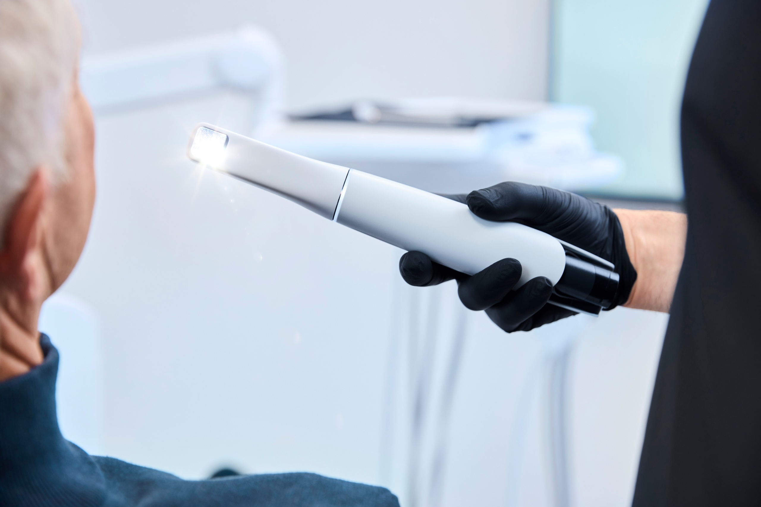 Intraoralscanner mit leuchtender Aufnahmespitze am Behandlungsplatz