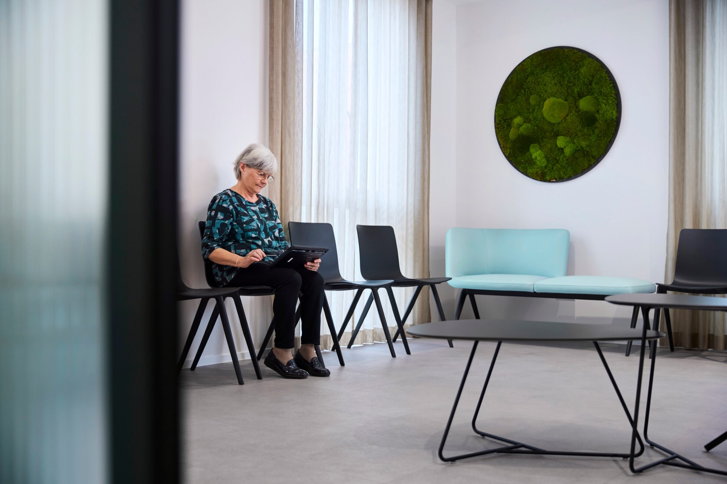 Person im Wartebereich der Praxisklinik am Rhein