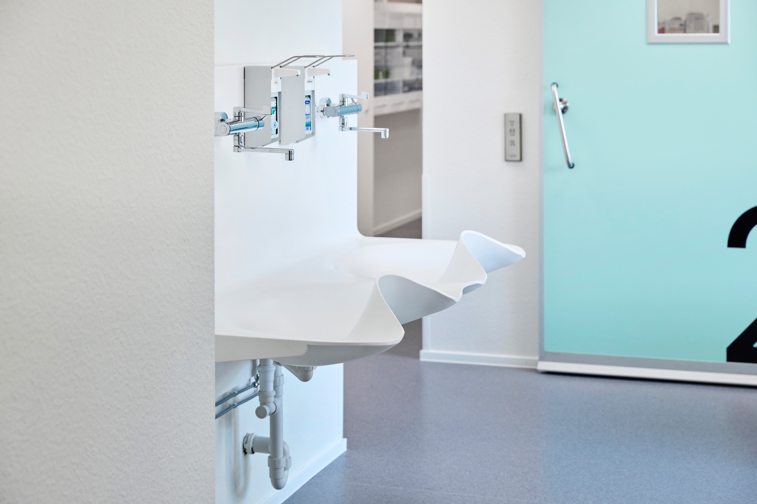 Handwaschplatz mit Armaturen im Flur vor den Behandlungsbereichen